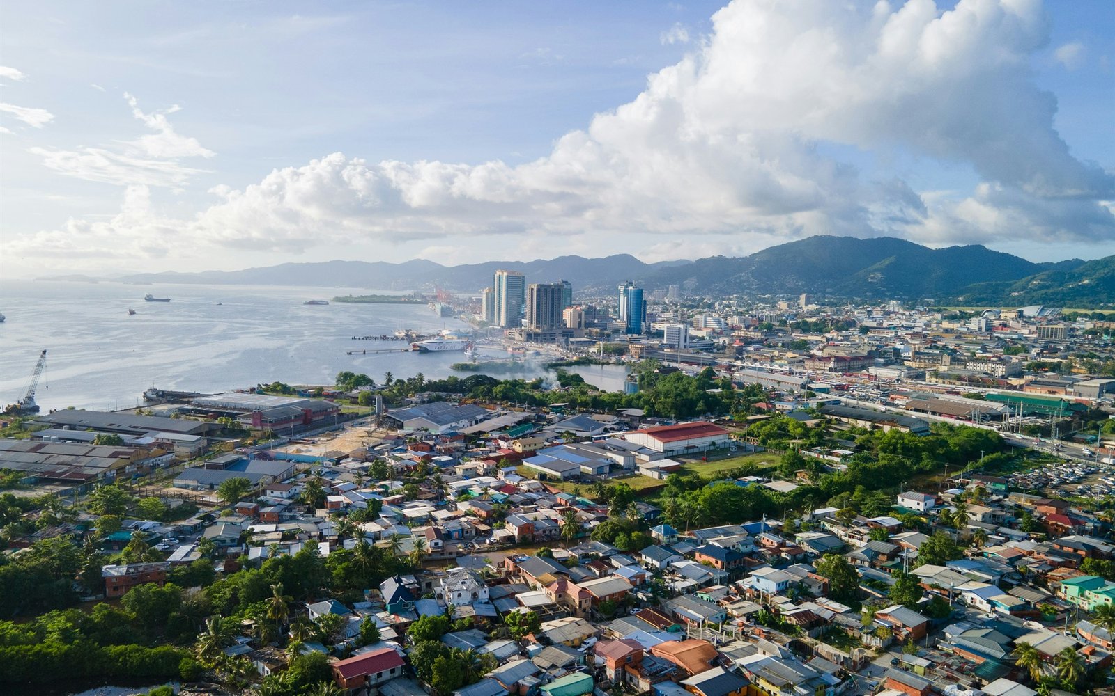 Vista aérea de Port of Spain, Trinidad y Tobago, con ciudad, costa y montañas.